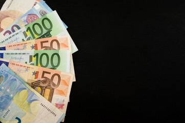 folded euro banknotes on a black background. Space for text. Business concept.