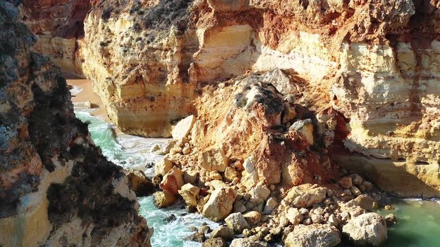Crumbled eroded rock formations in Marinha Beach south of Portugal, Aerial approach turning shot