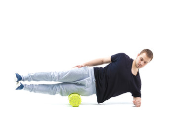 A man makes strengthening exercises for the body with special sports equipment. Self massage increases the body's tone