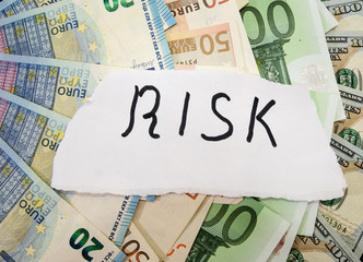 inscription risk on a background of euros and dollars. Business concept.