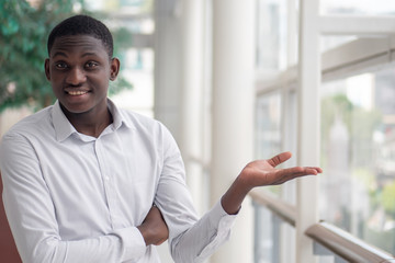 happy smiling positive business man pointing up finger to space; concept of way point, direction, plan, open idea pointed up by smart casual black African man