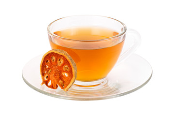 Glass cup of Bael fruit juice or quince tea and dried bael sliced fruit ( Aegle marmelos or wood golden apple ) isolated on white background. Herbal tea and healthy drinks concept.