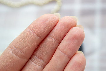 Cosmetic product on the fingers of a woman's hand, close-up.