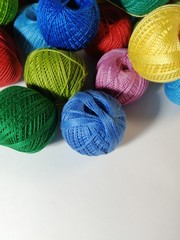 Balls of colored threads on a white background