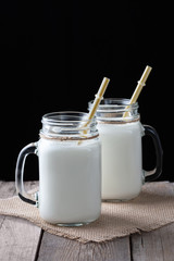 Glass cups with milk on a wooden rustic background