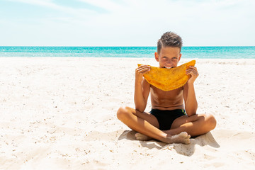 Street food concept. Young handsome hipster guy holding, eating meat pasty on the beach. Caucasian, Cheburek.