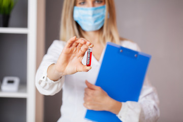Obraz na płótnie Canvas Health worker holds a test tube with a test of covid-2019