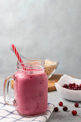 Freshly homemade smoothie with cranberries, oatmeal and yogurt in a mug jar on a gray table. Healthy eating concept. Vertical image with copyspace