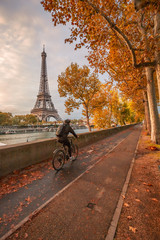 Cyclist rolling on a bike path along the Seine on an autumn day