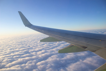 Airplane wing in the sky. View from a great height.