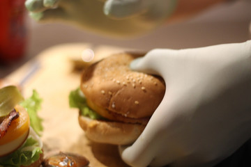 Making  burger with cheese, kitchen. Photo of Making Burgers and Street fast food. Blue lab gloves. Occupational Safety And Health. Stock photo.