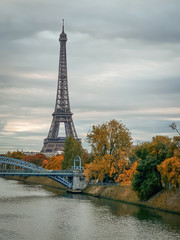 Obraz premium Eiffel tower in Paris France on an autumn day surrounded by brown leaves of trees, Tour Eiffel in the fall