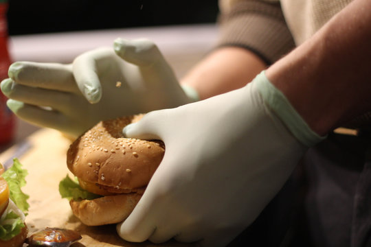Making  burger with cheese, kitchen. Photo of Making Burgers and Street fast food. Blue lab gloves. Occupational Safety And Health. Stock photo.