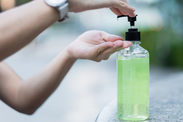 Woman hands using wash hand sanitizer gel dispenser, against Novel coronavirus or Corona Virus Disease (Covid-19) at public Indoor. Antiseptic, Hygiene and Healthcare concept