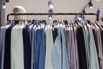 Men's clothing store. Men's outerwear weighs on a hanger in a store. How to dress a man in 2020. Strict shirts and sweaters. Casual, work clothes.