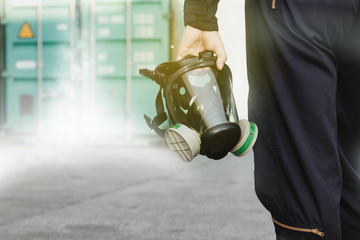 Male industrial technician who holds a respirator mask, an ammonia odor mask, NH3 to control and...