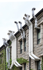 Facade of an old building with lot of plastic ventilation exhaust pipes