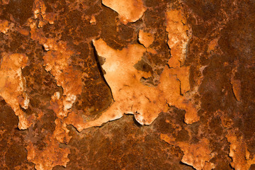 rusty metal surface with yellow and white  paint flaking and cracking texture