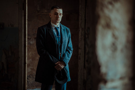 A man posing in the image of an English retro gangster in Peaky blinders style.