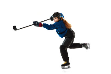 Young female hockey player with the stick on ice court and white background. Sportswoman wearing...