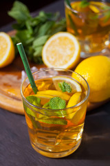 Two glasses of cold refreshment tea with ice and lemon fruit.