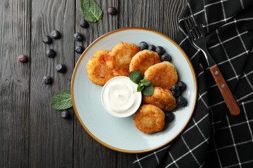 Breakfast of cheese pancakes on wooden background, top view