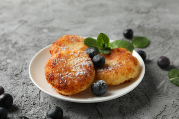 Breakfast of cheese pancakes on grey background, close up