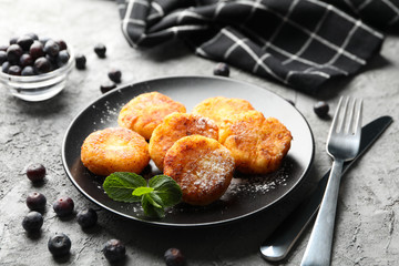 Breakfast of cheese pancakes on grey background, close up