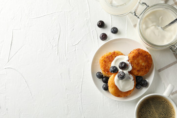 Breakfast of cheese pancakes on white background, top view