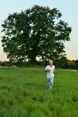 Portrait of happy man running in summer field