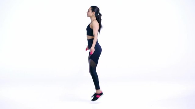 side view of sportswoman exercising with skipping rope on white