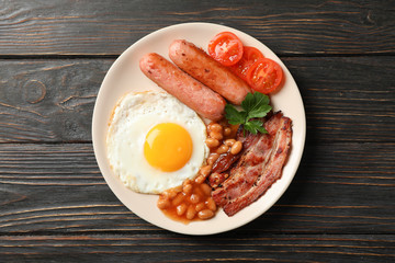 Delicious breakfast or lunch with fried eggs on wooden background, top view