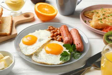 Delicious breakfast or lunch with fried eggs on wooden background, close up