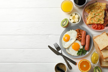 Delicious breakfast or lunch with fried eggs on white wooden background, top view