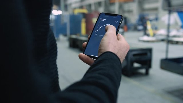 Engineer swiping through forecast analysis app on smartphone