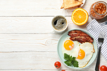 Delicious breakfast or lunch with fried eggs on white wooden background, top view