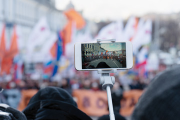 Blogger is reporting using a smartphone from a city street during a mass political action in...