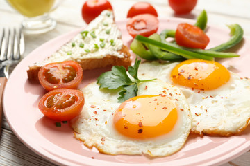 Delicious breakfast or lunch with fried eggs on wooden background, close up