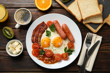 Delicious breakfast or lunch with fried eggs on wooden background, top view