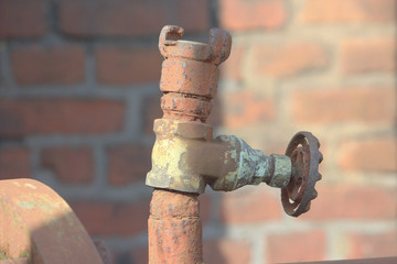 rusted iron pipe with shut-off valve in an old factory