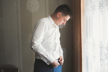 Fototapeta premium Young handsome man relaxing at his apartment in a hotel after business meeting