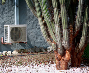 Split system air conditioner unit on stucco wall in hot tropical climate. Selected focus on air conditioner.
