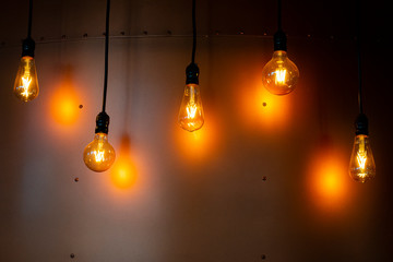 Decorative lamps with apparent filament. Metal background with exposed screws.