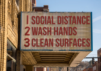 A photo illustration of a movie cinema billboard with three basic rules to avoid the coronavirus or...