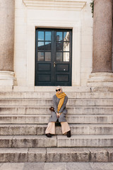  portrait of young European Muslim women with hijab exploring old city of Split as tourist. Diocletian's palace. She is sitting on stairs. 