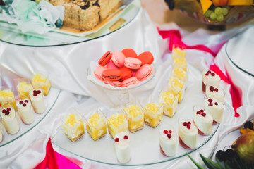 Delicious and tasty dessert table with cupcakes shots at reception closeup