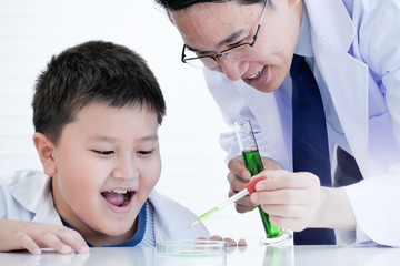 A little boy and scientist teacher doing science experiments in the laboratory.