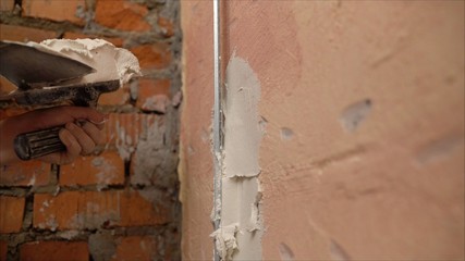 The use of mortar for wall repairs. hand of builder worker use trowel plastering concrete at wall