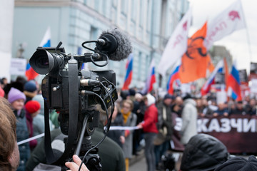 Fototapeta na wymiar Videographer is reporting from a city street during a mass political action in Moscow, Russia. Camera is up of the crowd