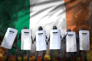 Ireland police swat in heavy smoke and fire protecting peaceful people against riot - protest fighting concept, military 3D Illustration on flag background